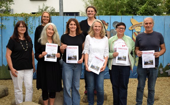 © Quelle: Valentum Kommunikation GmbH / Martina Weininger  Das Bild zeigt acht Personen, ein Teil von ihnen hält ein Dokument in die Kamera.