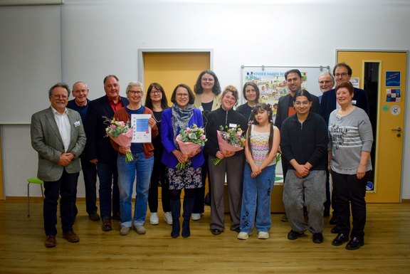 ejsa Regensburg / Valentum Kommunikation GmbH (Martina Weininger) Das Foto zeigt ein Gruppenbild mit 14 Personen, 3 von ihnen halten einen Blumenstrauß vor sich.